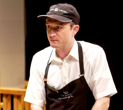 Andrew Jessop plays T.C., the earnest, clarinet-playing manager of a Caribou Coffee shop
